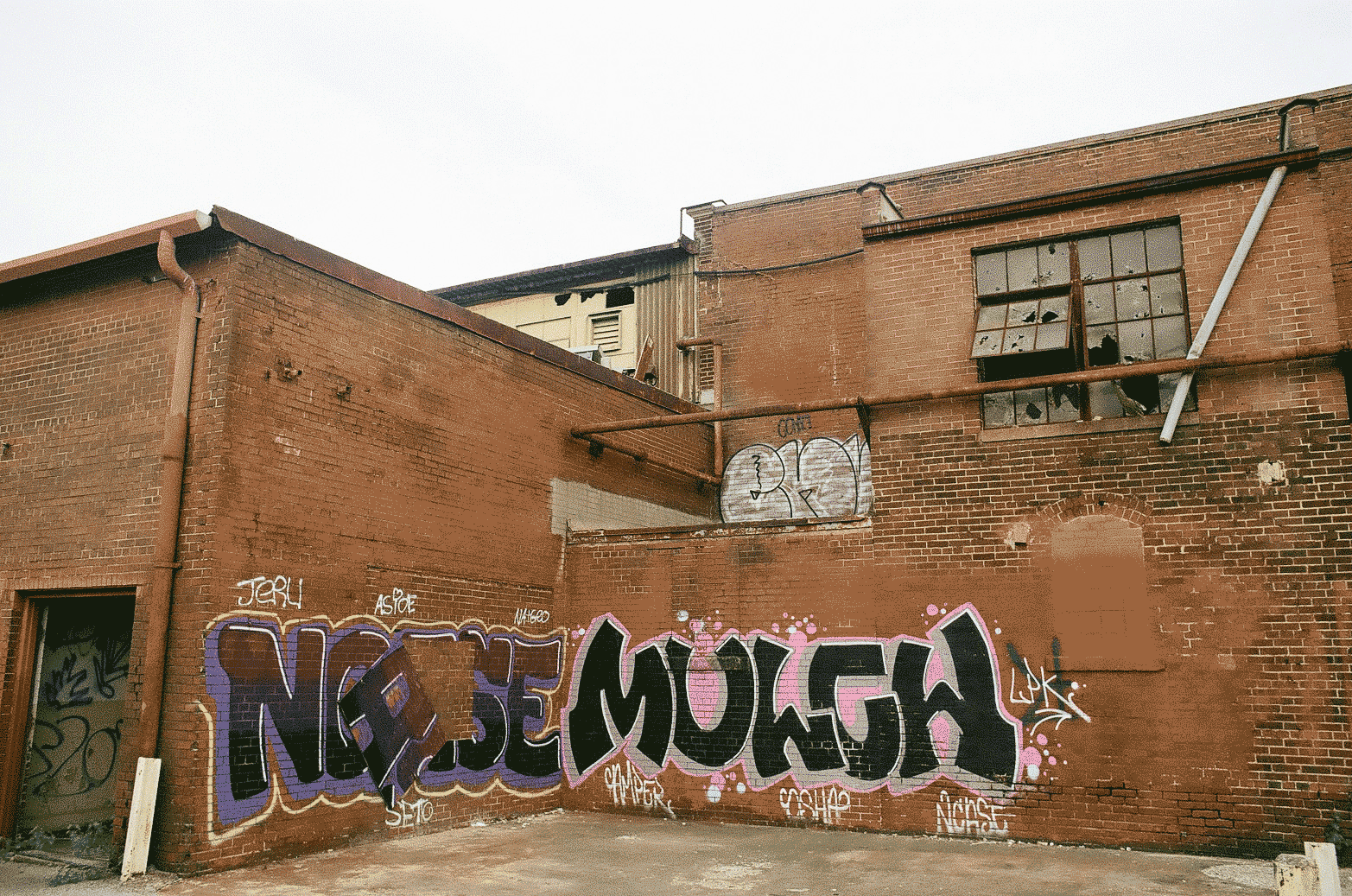 Industrial building with graffiti spelling the word Mulch